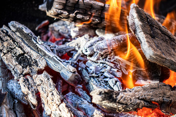 Burning firewood and coals in the grill. Close-up. Macro shooting. Burning fire. Grilling meat. The energy of fire