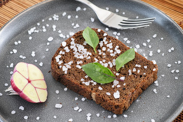 Whole grain organic bread with sea salt and basil leaves