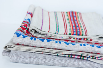A stack of woven linen towels with embroidery, traditional handmade in Ukraine