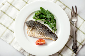 Sea bass fillet fried on a plate, seafood.