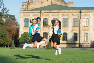 Unstoppable energy of little jumping schoolgirls school background, back to school concept