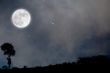 Fototapeta na wymiar Full moon in starry night over village.