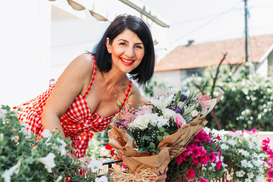 Beautiful Brunette Middle Aged Woman Holding Bouquet Of Flowers.