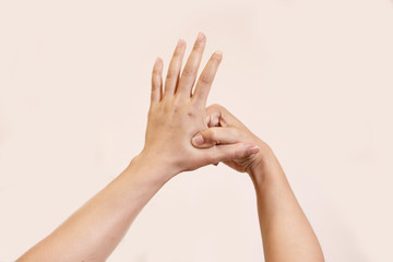 Young beautiful woman has pains in a hand. The hand hurts a woman isolated on white background.