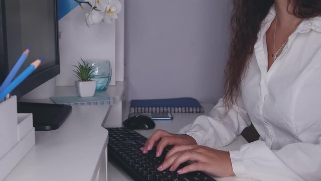 A young girl is typing on the keyboard.