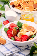Porridge of tiny pancakes with berries. Trendy food.