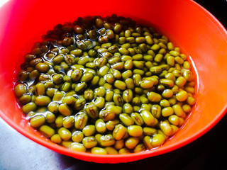 Green gram placed in soaked condition for sprouting in an orange bowl