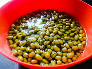 Green gram placed in soaked condition for sprouting in an orange bowl