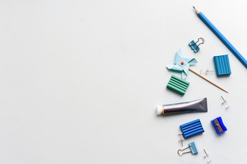Stationery on a blue background. Scissors, pencils and plasticine, items for creativity. Copy space