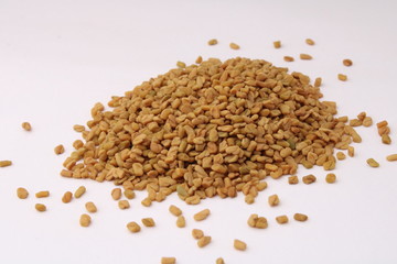 Seeds of fenugreek on white background closeup.