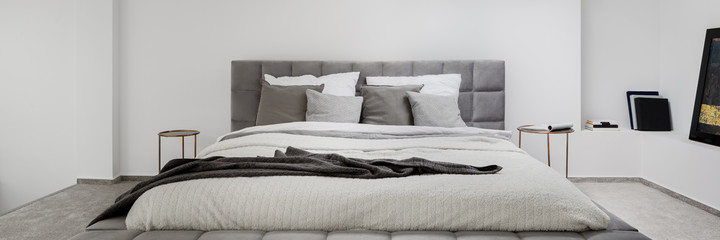 Panorama of big, gray quilted bed