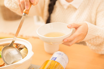 鍋料理を食べる女性