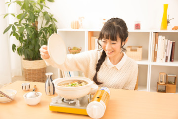 お鍋の蓋を開ける女性
