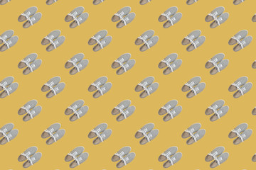 seamless pattern of grey classic sneakers on yellow background
