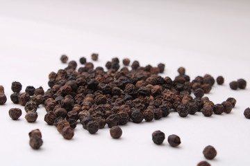 Black pepper placed on a white background.