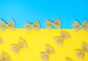 Close up pattern of noodles farfalle also known as bow-tie or butterfly pasta placed on colorful background.