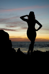 Fototapeta premium silhouette of girl at the beach at sunset
