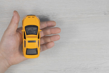 Toy taxi car in hand. Yellow taxi car.