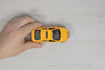 Toy taxi car in hand. Yellow taxi car.