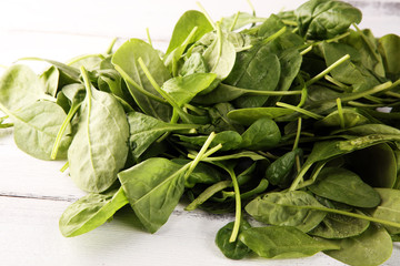 Fresh spinach leaves on rustic wooden table. Healthy salad concept