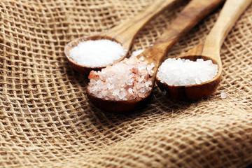 Sea salt and himalayan on spoon. Crystals of salt on background
