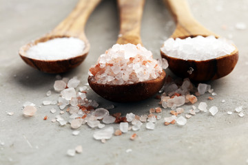 Sea salt and himalayan on spoon. Crystals of salt on background
