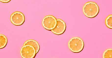 Lemon colorful pattern on pink background. Fresh citrus slices closeup, lemon wallpaper, top view. Lemonade creative concept, fashionable trendy summer beverage, flat lay