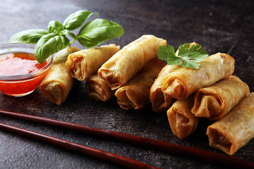 Fried chinese spring rolls with sweet chili sauce on rustic background