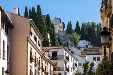 Fototapeta na wymiar View of the Granada neighborhood of Realejo with its typical white houses with cypress trees
