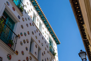White facade adorned with colorful ceramic suns
