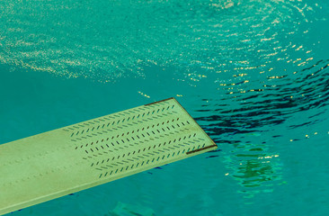 a springboard to dive into the pool / the first floor of a trampoline in the background water of a swimming pool 