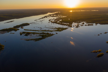 Spring flooding on the river, flooded forest, islands on the river. View from a drone, a bird's-eye view. View without the presence of people in the evening. 