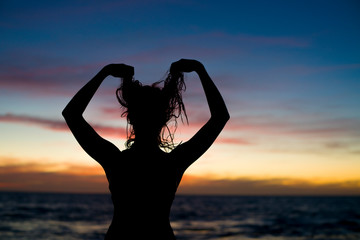 Fototapeta premium silhouette of girl at the beach at sunset