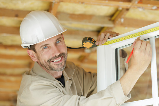 Man Measuring Window Prior To Installation