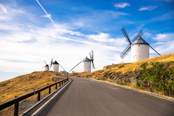 Photo of some beautiful and historical windmills located in Consuegra, Toledo, Spain during a sunny day of summer in a natural place.  - obrazy, fototapety, plakaty