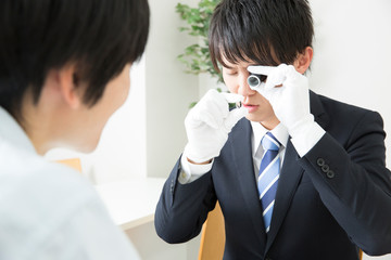 査定する鑑定士と客