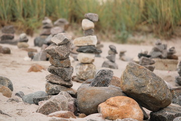 Fototapeta na wymiar Türme aus kleinen Steinen stehen am Strand