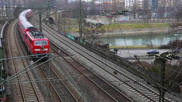 Red passenger train is crossing a bridge in Stuttgart, German.