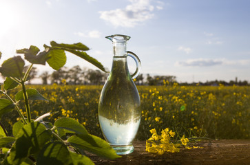 Rape oil and flower on wooden table.