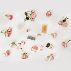 Natural homemade organic soap with pink roses and petals on white background. Spa concept, top view, flatlay 