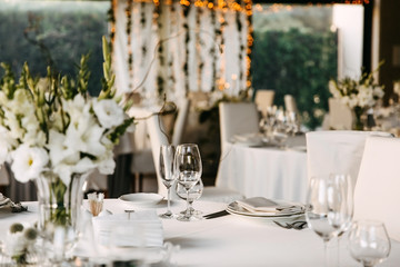 Decorated table at a restaurant. Centerpiece and tableware at a wedding party.