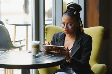 Young woman using tablet computer in coffee shop