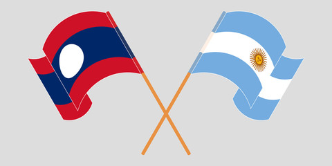 Crossed and waving flags of Laos and Argentina