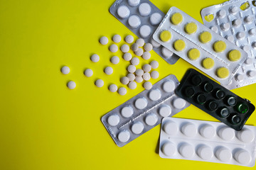 Pills of various medicine, tablets on a yellow background. Many tablets and tablets with space for text. Healthcare. View from above. Copy space. New image. Pharmaceutical picture. Close-up. Close-up.