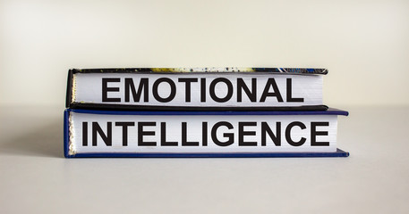 Books with text 'emotional intelligence' on beautiful white table. White background. Business concept. Copy space.