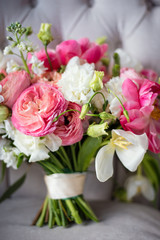 delicate bridal bouquet of pink and white flowers, flower close-up, selective focus,  bouquet is on  light gray armchair
