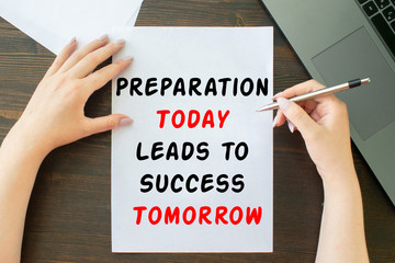 Preparation Today Leads to Success Tomorrow inscription on sheet a4, the girl writes next to the laptop