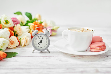 Cozy morning. Mothers day greeting flower card. Bouquet of flowers and alarm clock. Good morning. Creative breakfast for Woman day. Copy space. Easter spring still life scene. Coffee mug. Time concept