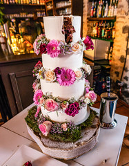 beautiful delicious Wedding cake in many tiers with fresh wild flowers and roses