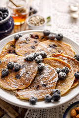 Pancakes with blueberries sprinkled with powdered sugar close up view